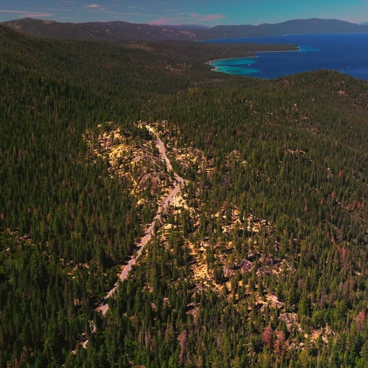 Splendido panorama pittoresco delle montagne della Sierra Nevada coperte di pini. Incredibile Lago Tahoe con barche. Vista dall'alto
