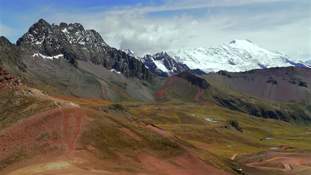 Paesaggio delle Ande peruviane: Ghiacciaio Ausangate, Montagna Arcobaleno Vinicunca del Perù, montagne della Catena del Vilcanota vicino ai ghiacciai Quelccaya. Mattinata soleggiata con cielo azzurro e nuvole, panorama mozzafiato della valle. Scatto statico.