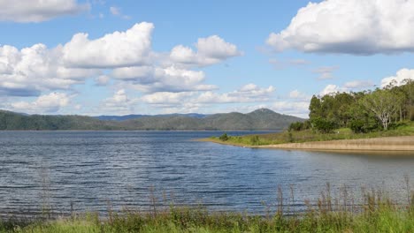 lago tranquilo con árboles y nubes por encima