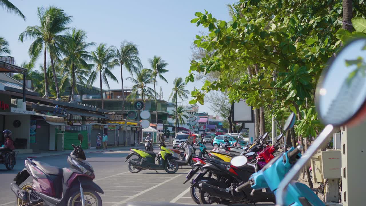 Motorbikes parked on roadside, tourists sunbathe sea Phuket city popular beach tourism summer day .