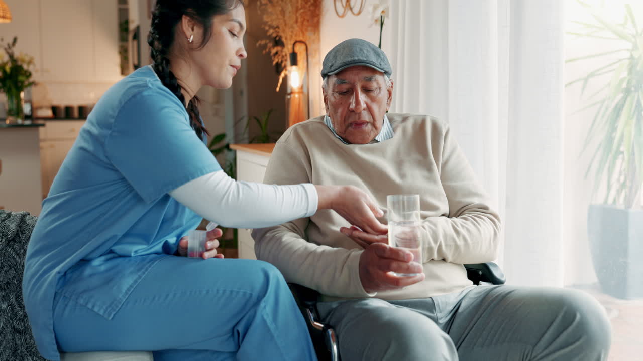 A woman helps an elderly man take his medication.