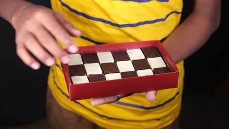 persona que sostiene una caja de chocolates