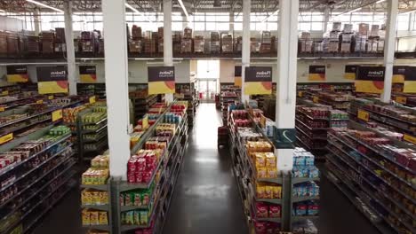 aerial view of a grocery store aisle highlighting organized shelves filled with colorful products and signs, capturing the essence of retail shopping experience