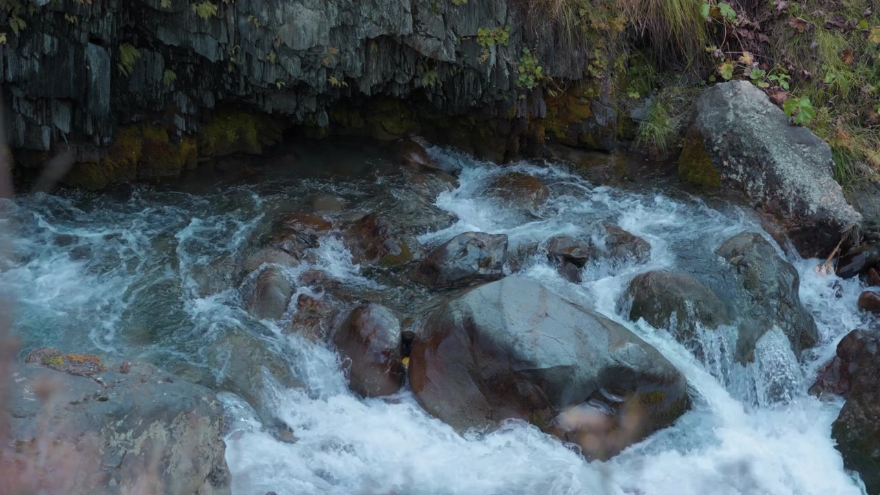 Fiume di montagna che scorre intorno a massi