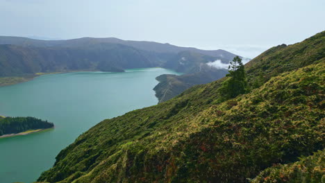 summer volcanic island panorama in sunny morning. clouds covering coast hills.