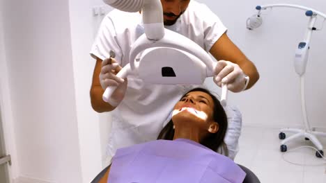 dentista examinando a una paciente femenina con herramientas