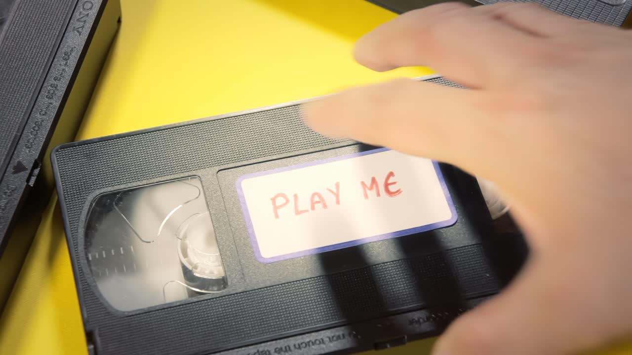 라벨이 붙은 vhs 테이프를 골라 다시 넣는 것