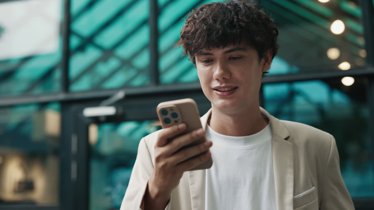 A man using his smartphone in front of a building