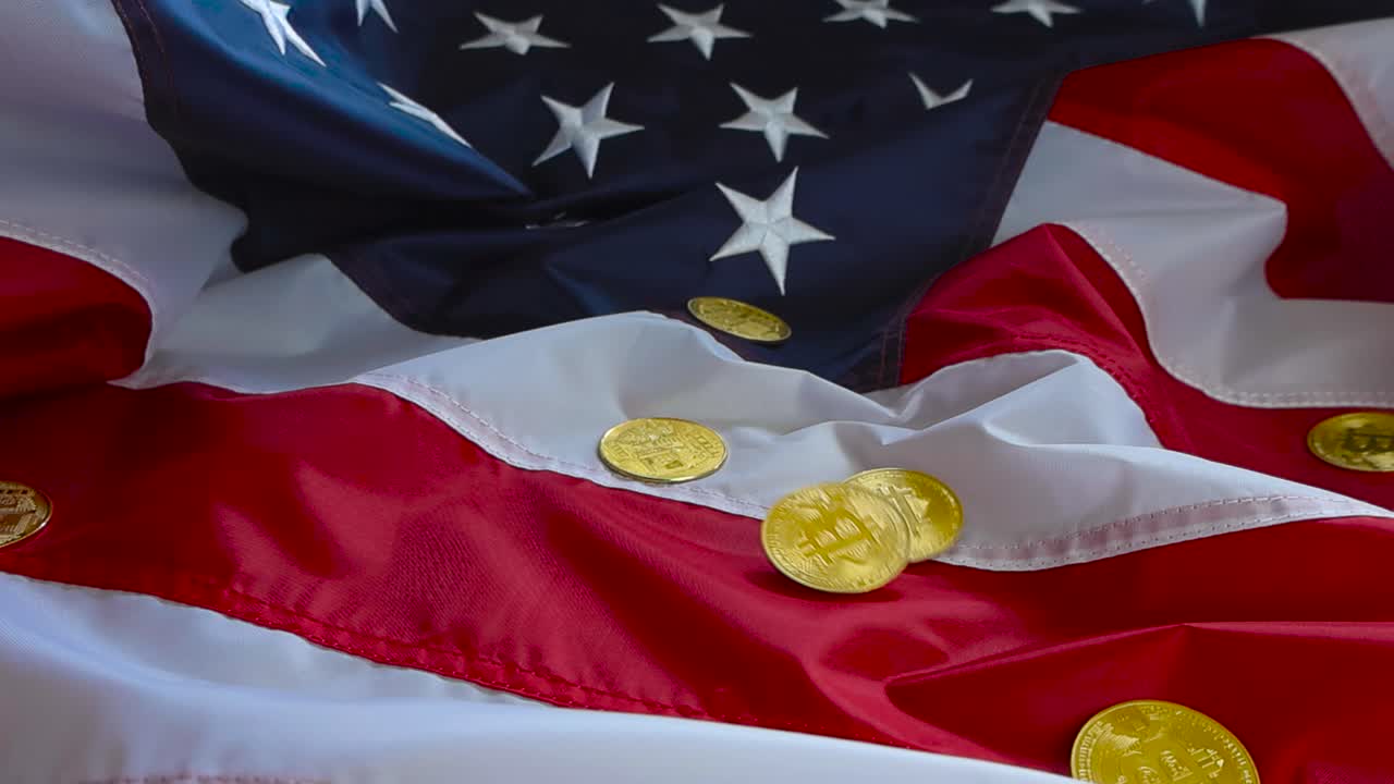 Gorgeous close up footage of golden shiny Bitcoin cryptocurrency money coins falling on an American US flag in slow motion making the flag move and coins are spinning when fallin on the colorful flag.