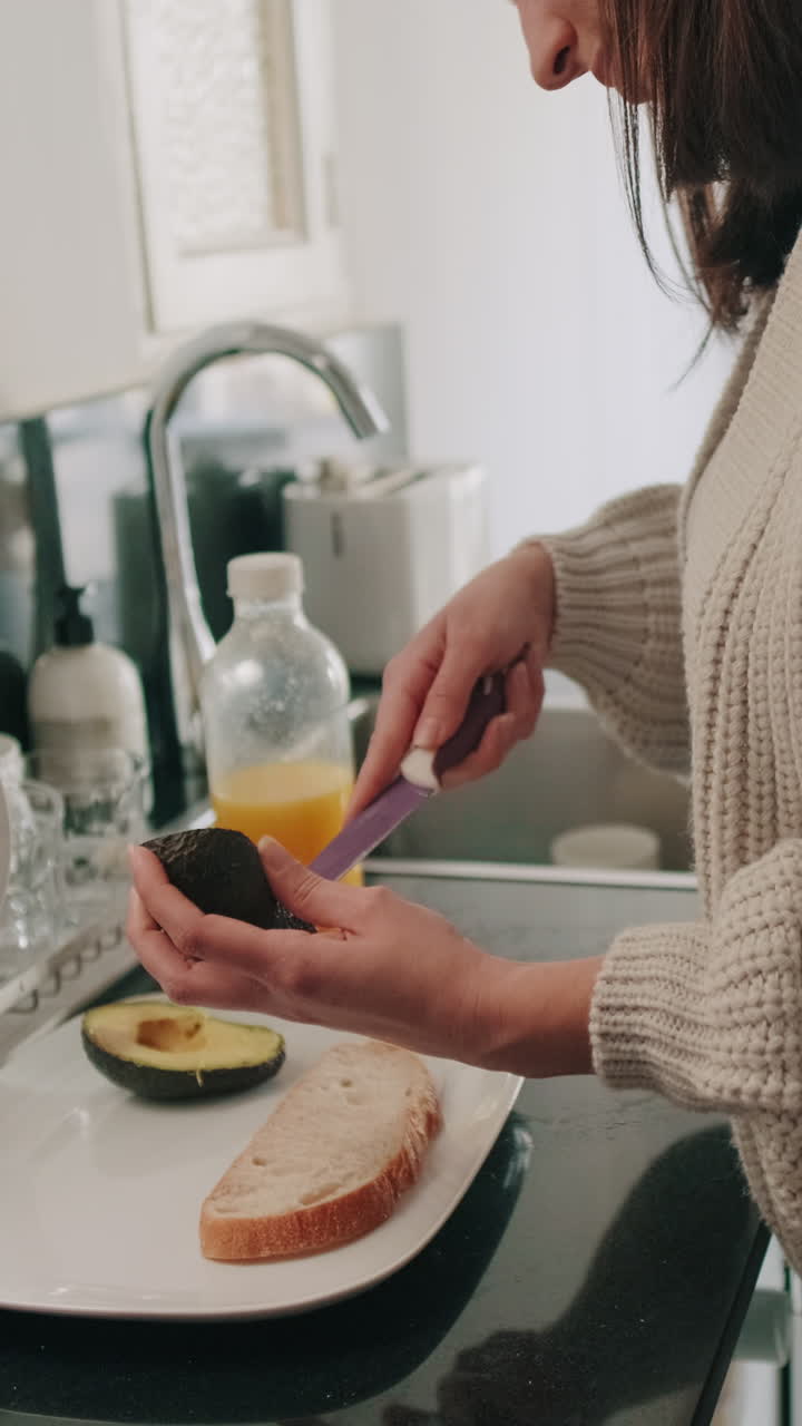 Mujer preparando una tostada de aguacate saludable en una cocina luminosa
