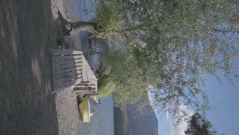 A-wooden-dock-pier-and-small-yellow-boat-next-to-a-beautiful-lake-in-Patagonia,-Argentina