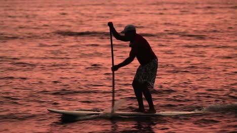 サンネットのラグーンでパドル サーフィンをする男性