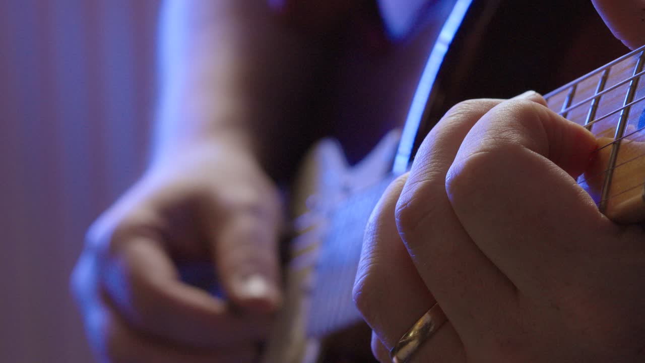 primer plano de manos tocando una guitarra eléctrica