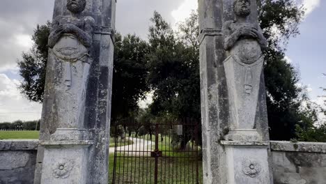 Mammalocchi-busts-travertine-columns-with-allegorical-figures-standing-at-entrance-to-private-villa-in-Umbria,-Italy