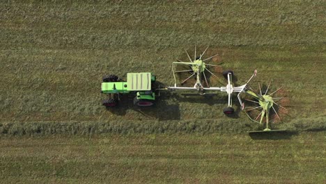 farm-tractor-spinning-hay-into-lines-for-baling