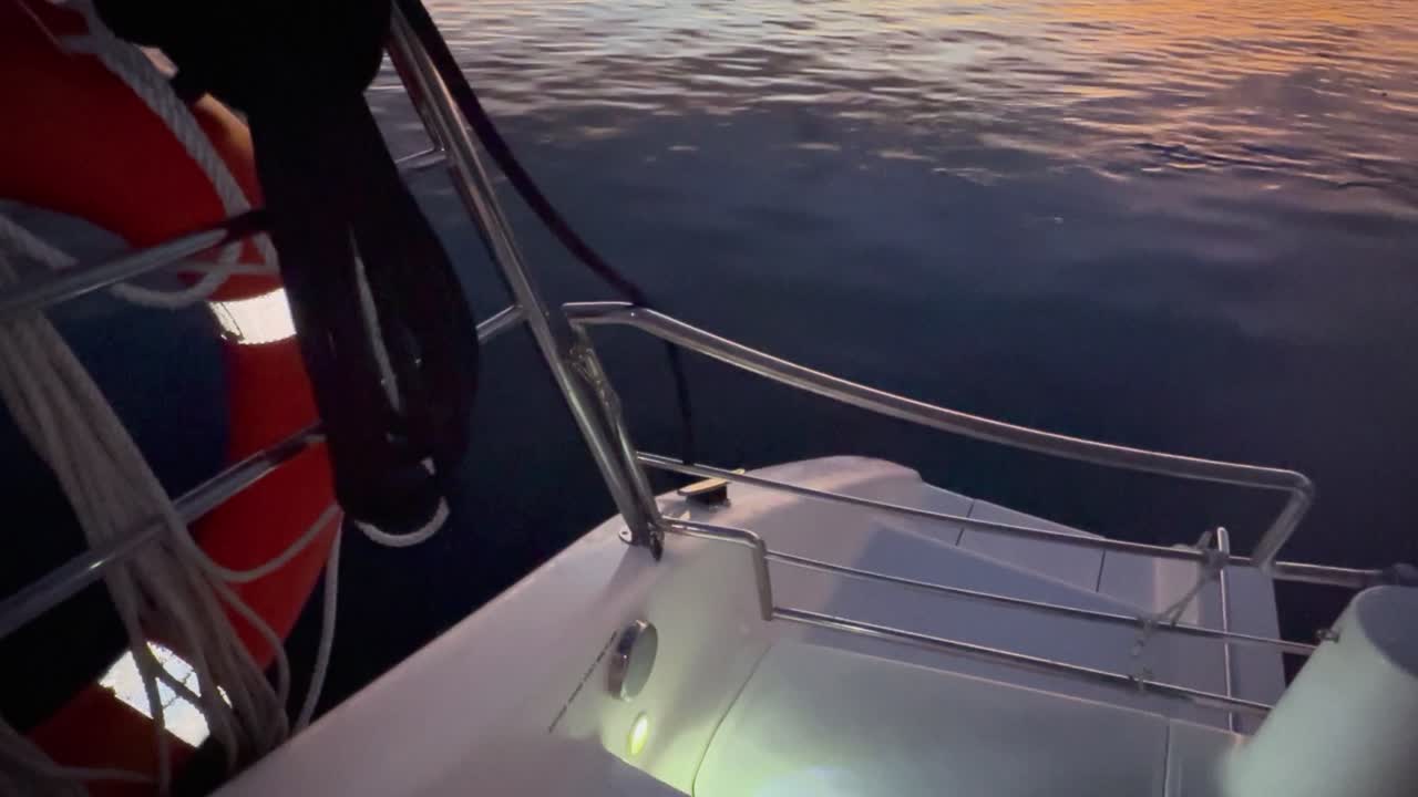 Guardando nell'acqua scura e immobile dal ponte di una barca con un salvagente illuminato.