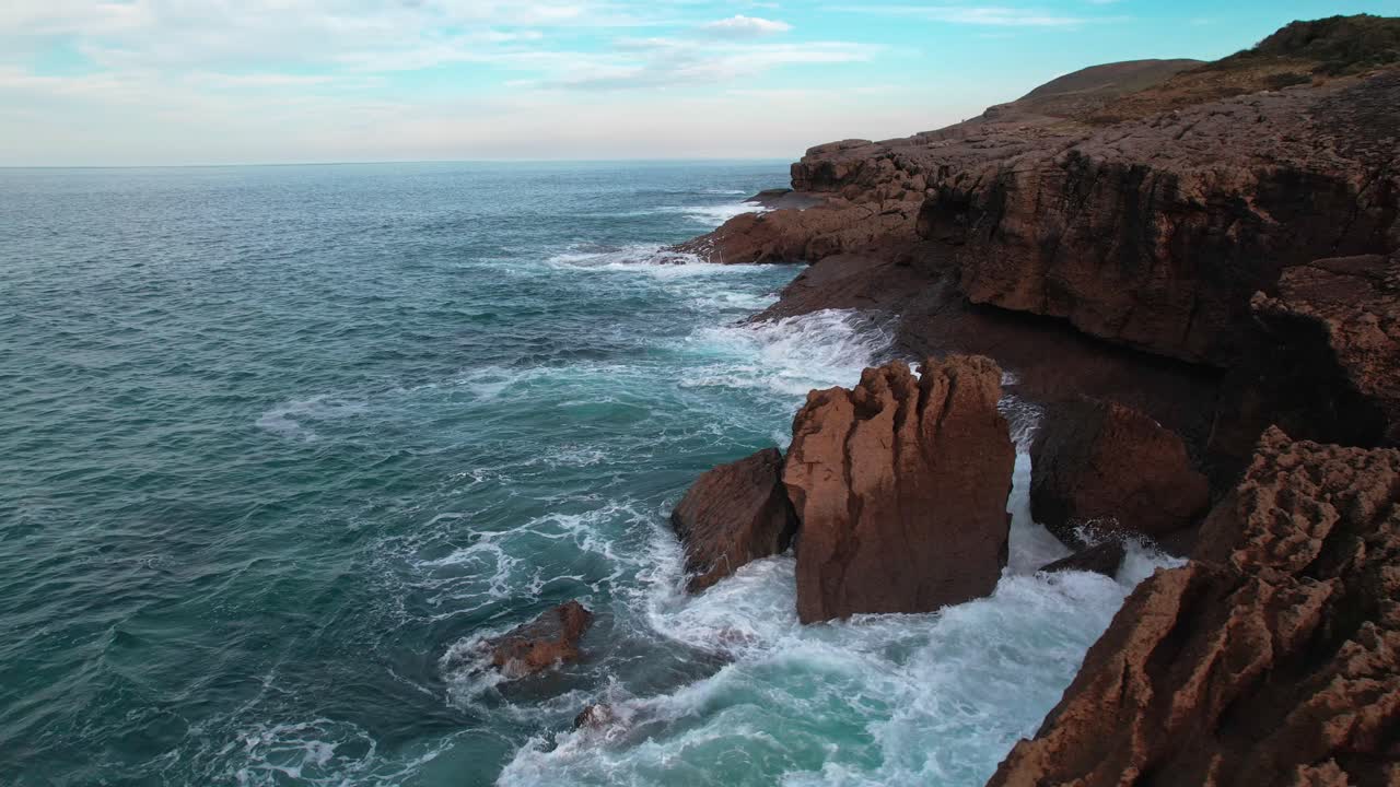 vista panorámica de las olas rompiendo con fuerza en la costa cantábrica con colores naturales en isla, un pueblo de cantabria, españa