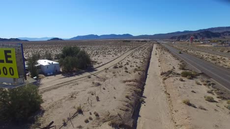una cartelera anuncia una gran extensión de tierra en el desierto a la venta y lista para el desarrollo