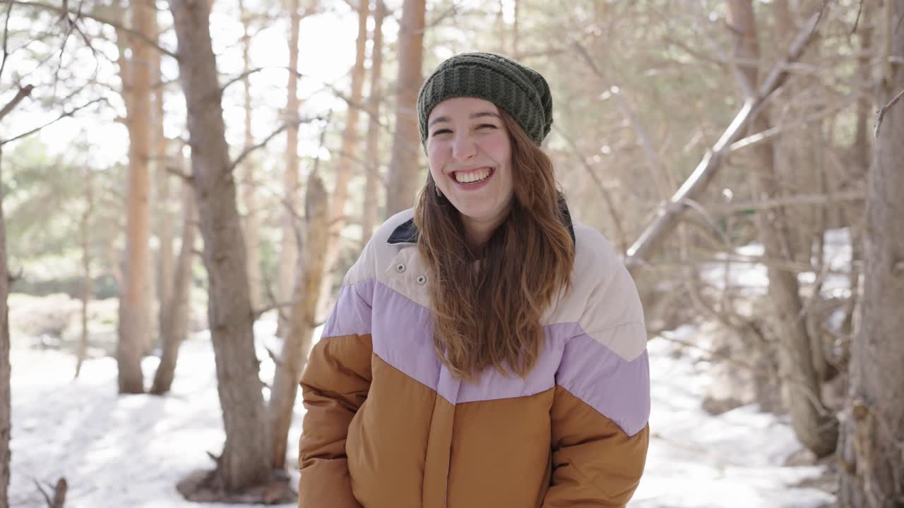 Woman smiling in a snowy forest during winter