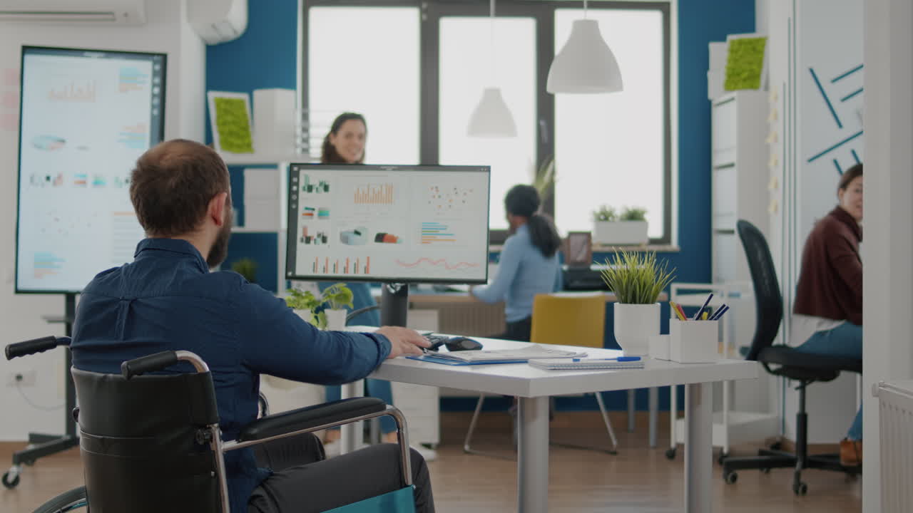 장애인 기업가가 창업 사무실에 들어오고, 동료들이 환영합니다.