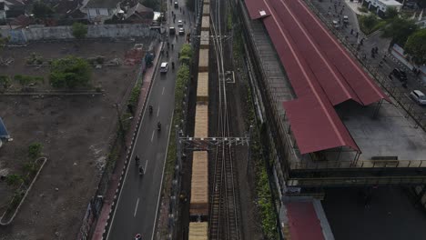 aerial footage of a freight train passing through the urban and railroad areas of yogyakarta city