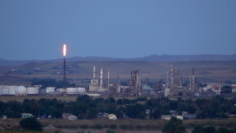 petroleum refinery in twilight with burning methane tower.