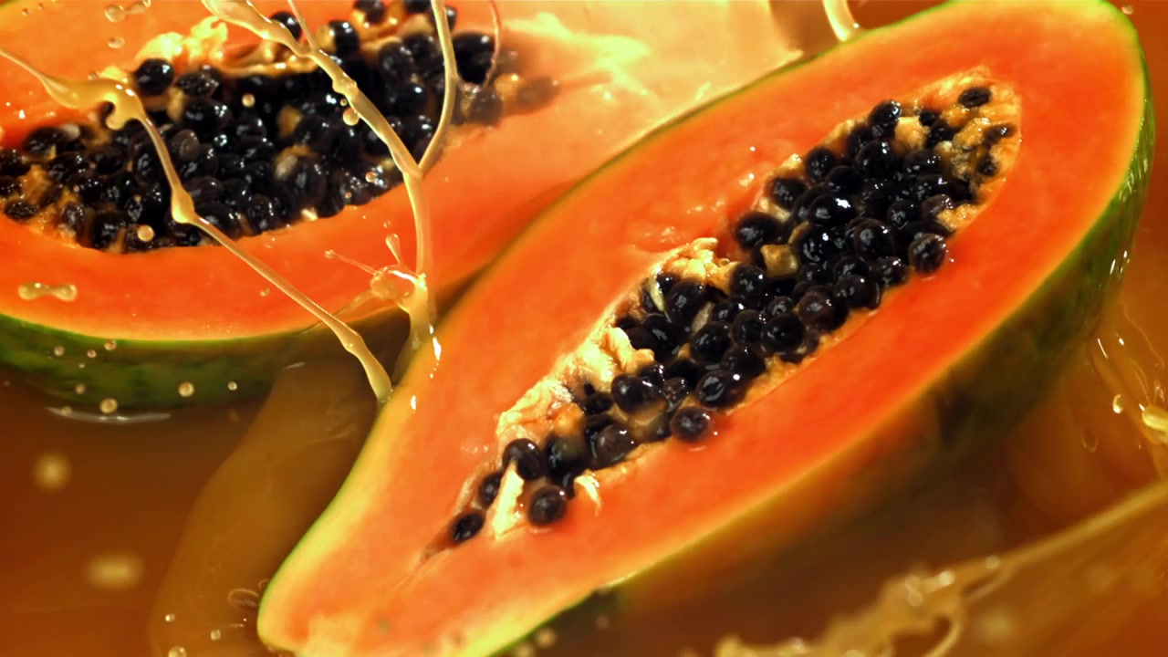 Mezze Papaye Fresche che Schizzano in un Liquido Arancione