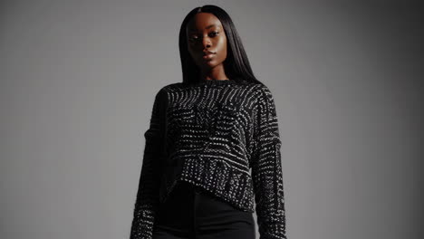 elegant young black woman posing in a patterned sweater