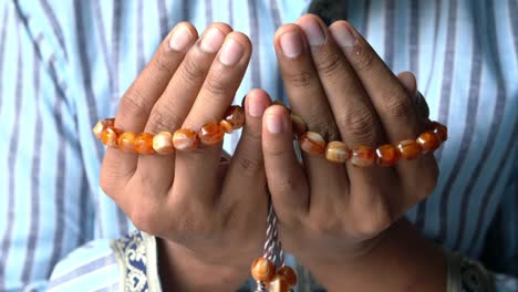 hands in prayer with prayer beads