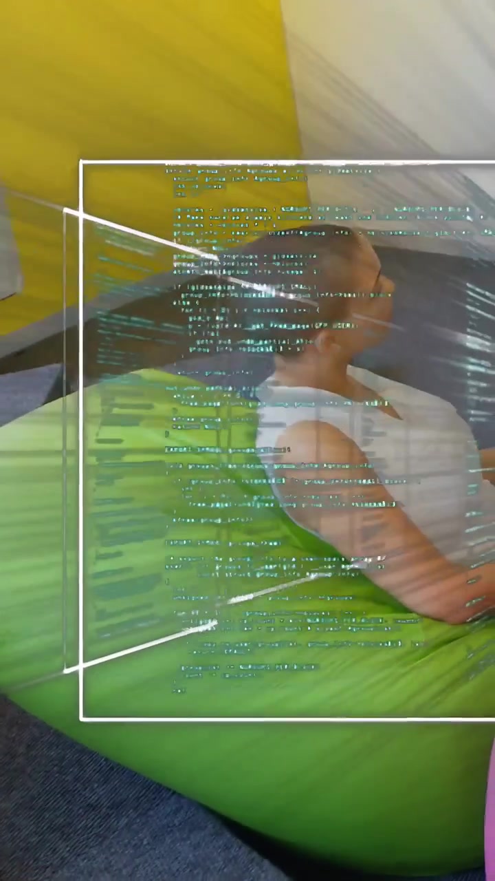 Vertical video: Woman on green beanbag reacting to code panels appearing, using mouse testing tech