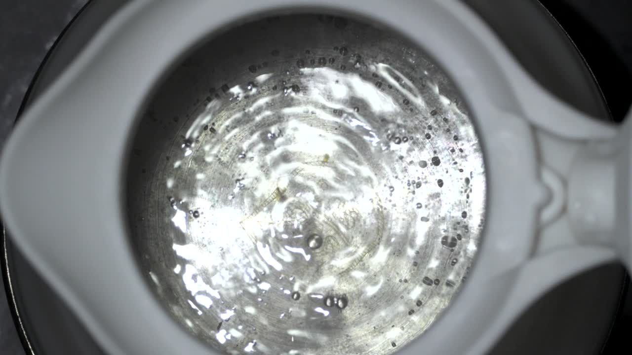 는 물 거품이 실리콘 케이틀 클로즈업 상단에서 느린 동작으로 나타납니다.