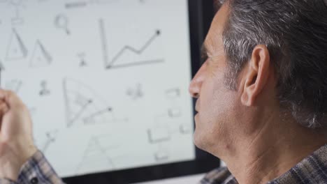 Thoughtful-man-over-shapes-on-computer.-He-is-trying-to-solve-it.