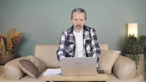 el hombre que mira la computadora portátil se frustra.