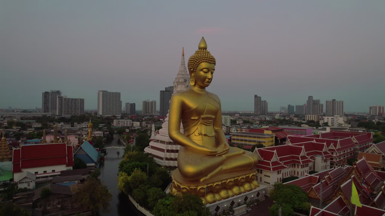 Scopri la serena maestosità del Buddha d'Oro di Bangkok attraverso affascinanti riprese con drone nel nostro filmato coinvolgente.