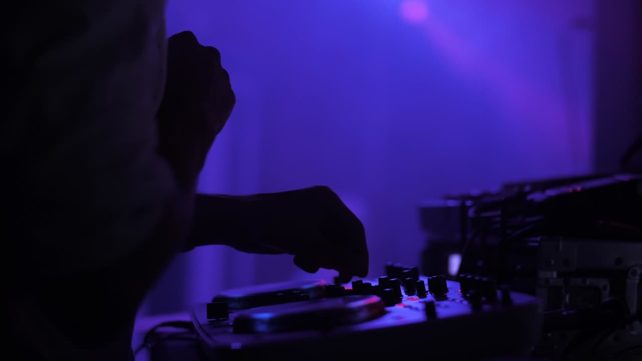 dj tocando en la fiesta, manos de primer plano, luz de colores