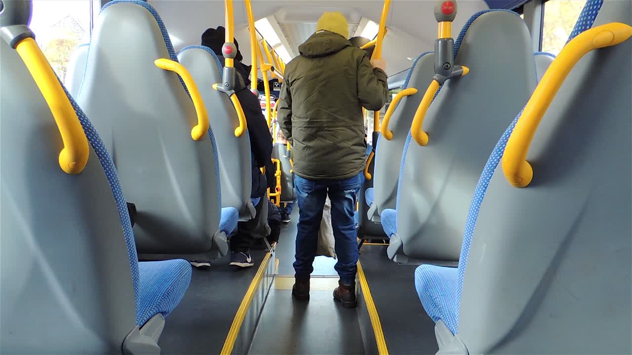 vista trasera del autobús con un hombre bajando del autobús y personas que usan el transporte público - toma constante de mano