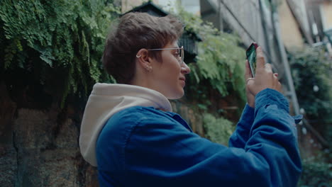 girl photographing street in old town with smartphone