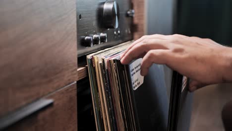 close up man hands browsing vintage vinyl records at home