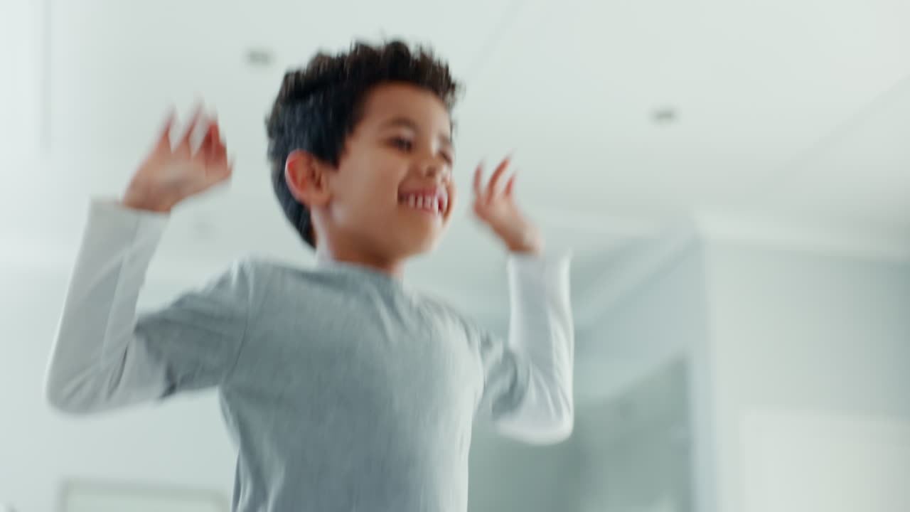 Kid, boy and jumping on bed in home while playing