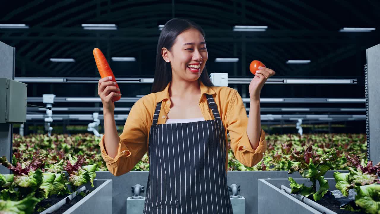 아시아 여성 농부 는 스마트  에서 따뜻 한 미소 를 지으면서 토마토 와 당근 을 들고 있다