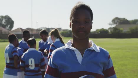 portrait of young adult female rugby player on a rugby pitch