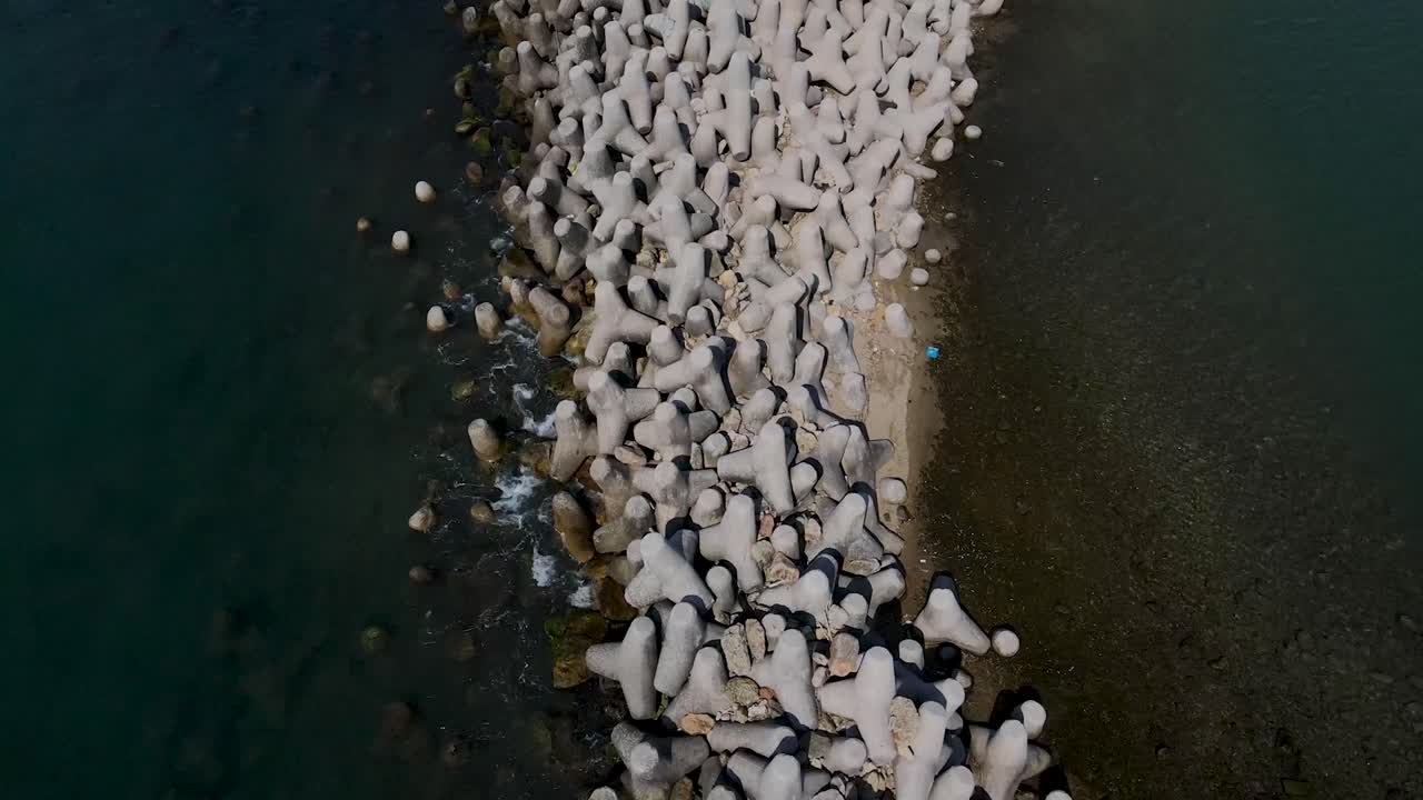 vista aérea de piedras de embarcadero gris en el puerto de grecia rodeado de agua azul oscuro del océano