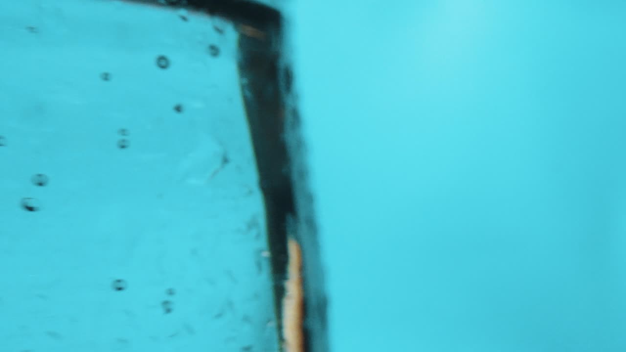 salpicando frambuesas y frutas de grosella negra en un vaso de agua con gas, estudio de primer plano