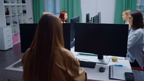 A group of businesswomen working together at their desks in an office.