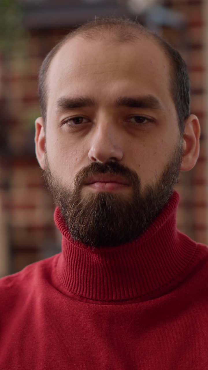 Ritratto di un uomo con la barba che indossa un dolcevita rosso