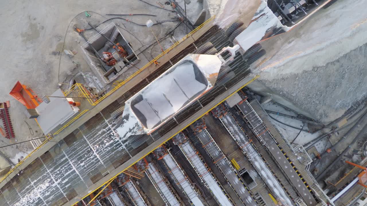 toma aérea cenital de un camión grande descargando sal en las salinas por evaporación solar en guerrero negro, laguna ojo de liebre, reserva de la biosfera de el vizcaino, baja california sur