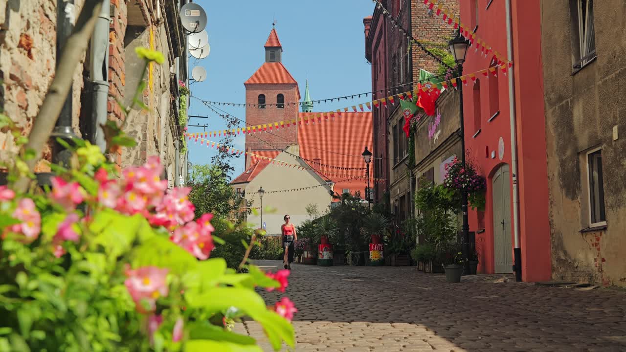 Spokojny widok w zwolnionym tempie kobiety idącej przez tętniący życiem stary Grudziądz