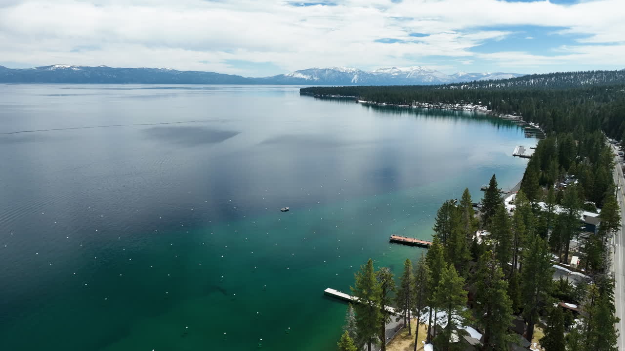 Panoramic drone shot circling the coastline of Lake Tahoe, spring day in USA