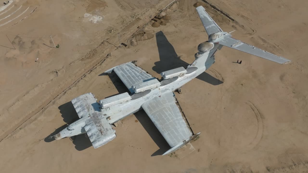 Vista aerea con drone di un aereo ekranoplano abbandonato di epoca sovietica che riposa su una costa sabbiosa vicino a Derbent, Repubblica del Daghestan, Russia, concetto di viaggio e storia