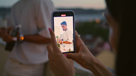 Woman-hands-recording-video-of-man-evening-balcony.-Relaxed-guy-play-guitar